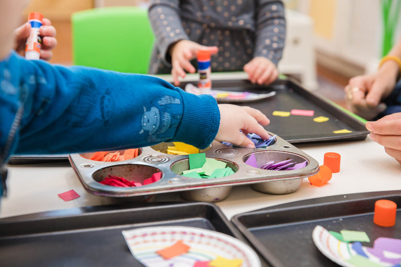 Kids playing with paper at Kids Garden.