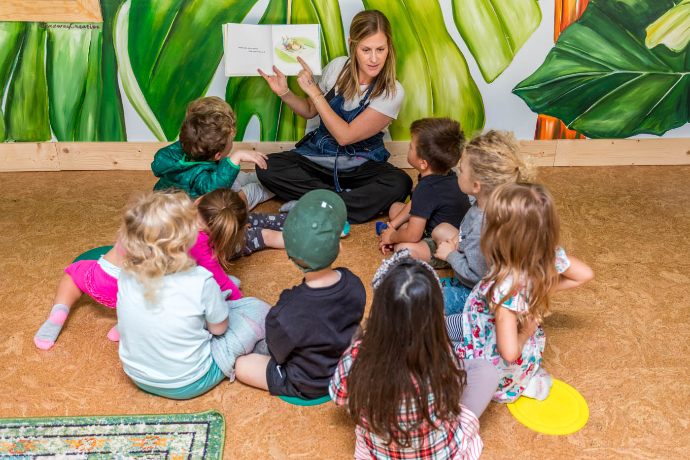 A teacher reading to a group of kids at Kids Garden's daycare and preschool in Summerville, SC.