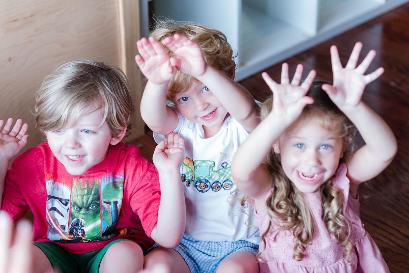 Kids rasing their hands during a game at Kids Garden.